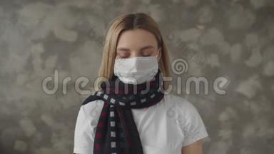 一个带着围巾，戴着医用口罩的生病女孩看着<strong>体温</strong>计，叹了口气。 一个年轻女子